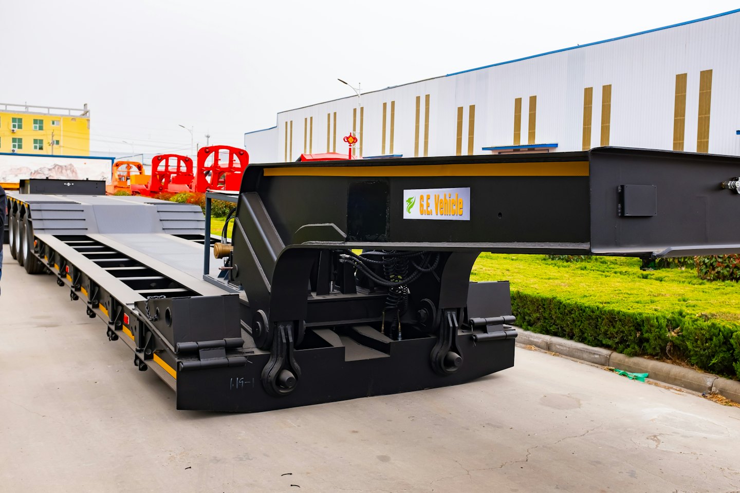 Heavy-duty multi-axle low-bed trailer parked on an industrial lot.