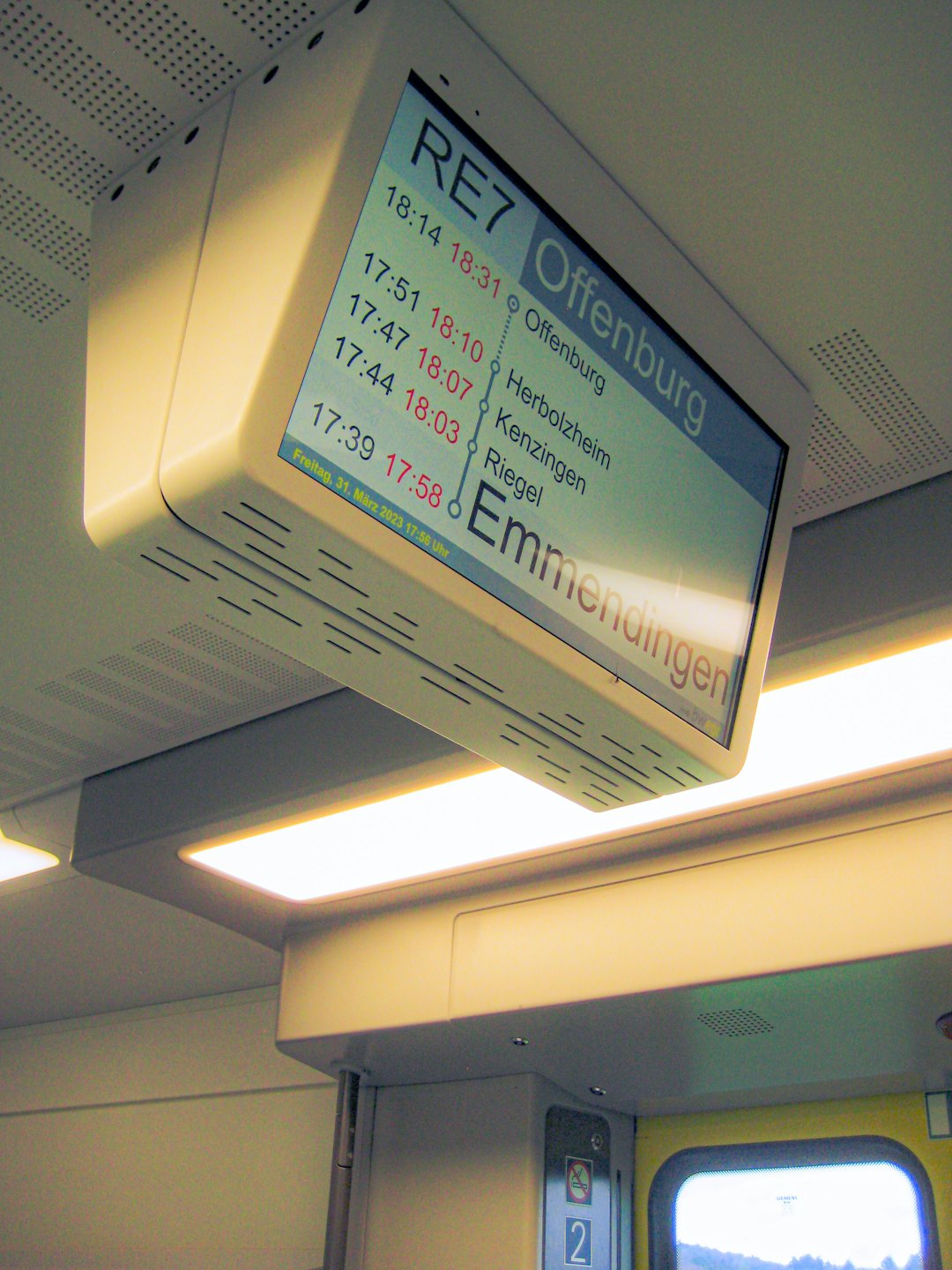 Digital display screen showing train route information inside a carriage.