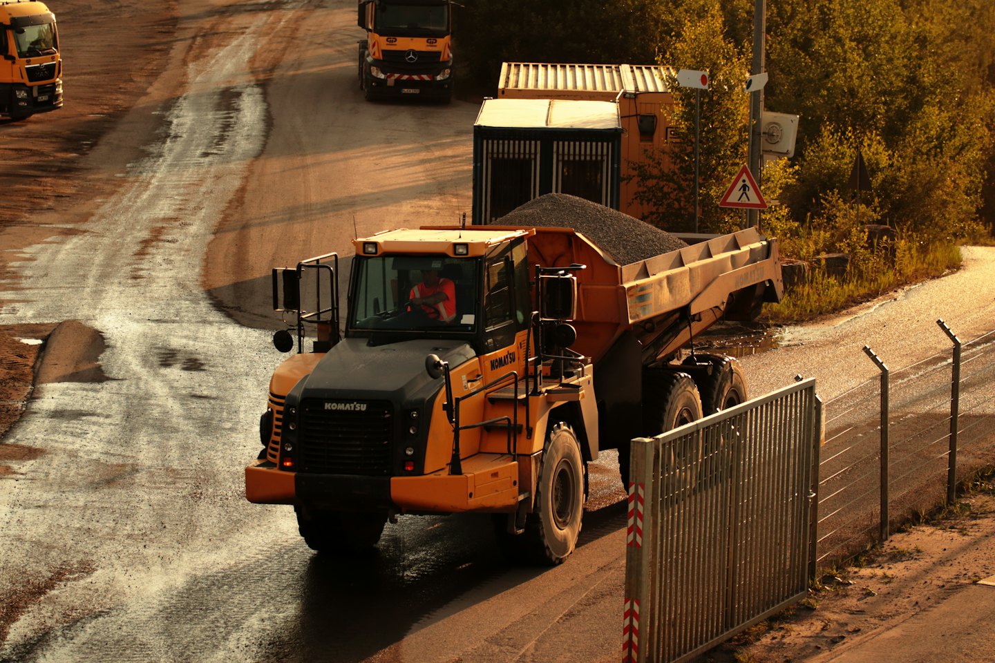 An industrial haul truck driving on an unpaved construction site.