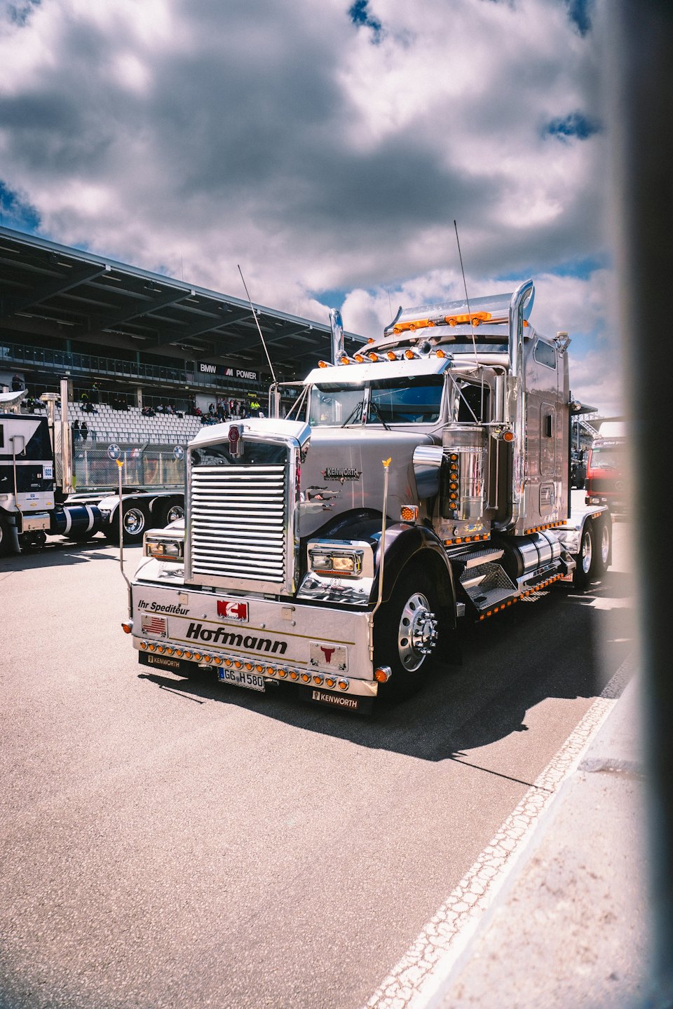 Polished chrome semi-truck parked at a race track.